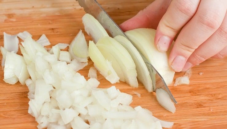 mani tagliano a fette cipolla