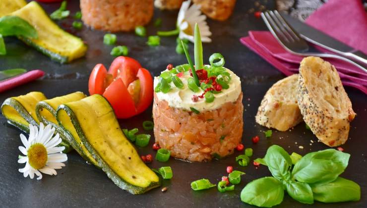 Tartara di salmone decorata con bacche rosa