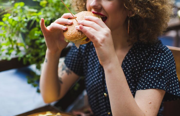 Una donna che mangia l'hamburger