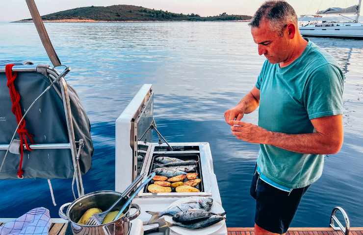 Uomo che cucina in barca